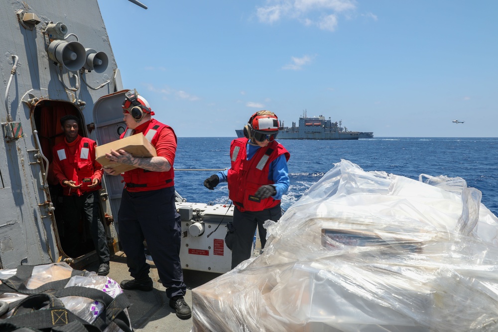 Sailors aboard the USS Howard conduct a vertical replenishment-at-sea with the USNS Wally Schirra in the South China Sea