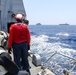 Sailors aboard the USS Howard conduct a vertical replenishment-at-sea with USNS Wally Schirra in the South China Sea