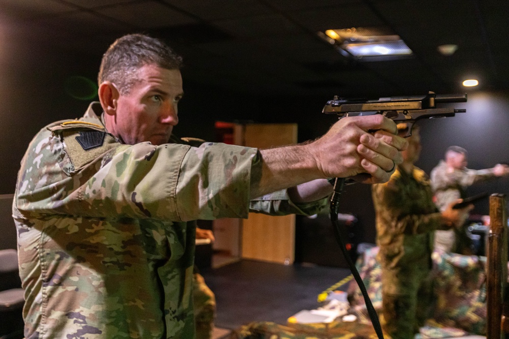 Capt. Zachary Grimes fires a simulation pistol