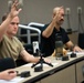 Reporters raise hands in mock press conference