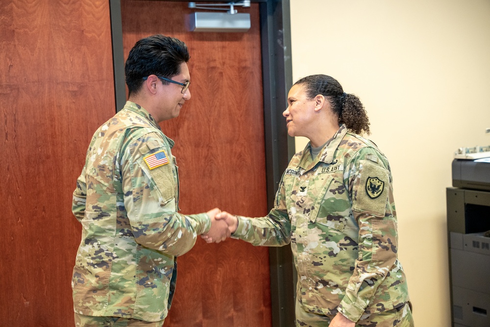 Spc. Taipe Receives Coin From Col. McGonegal