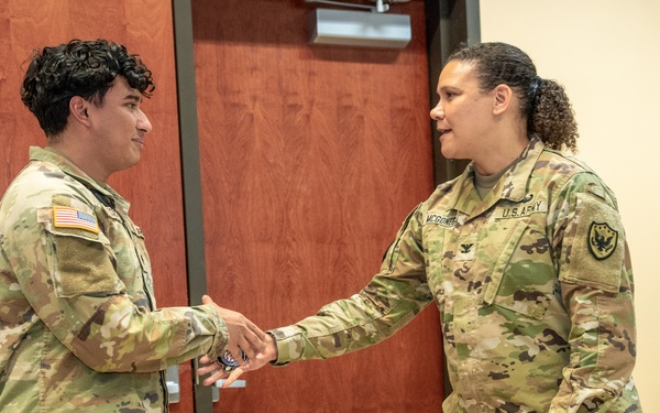 Spc. Flores Receives Coin From Col. McGonegal