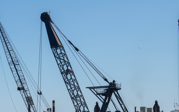 A Key Bridge Response crane operator removes wreckage