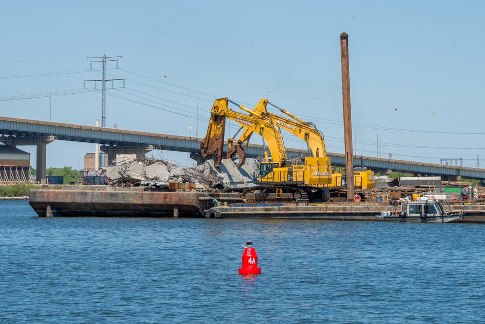 Key Bridge Response salvors use hydraulic shears to remove bridge wreckage