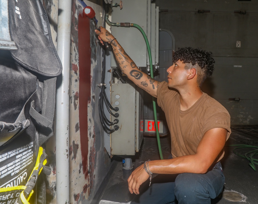 Sailors aboard the USS Howard apply primer to the ship's bulkhead in the South China Sea