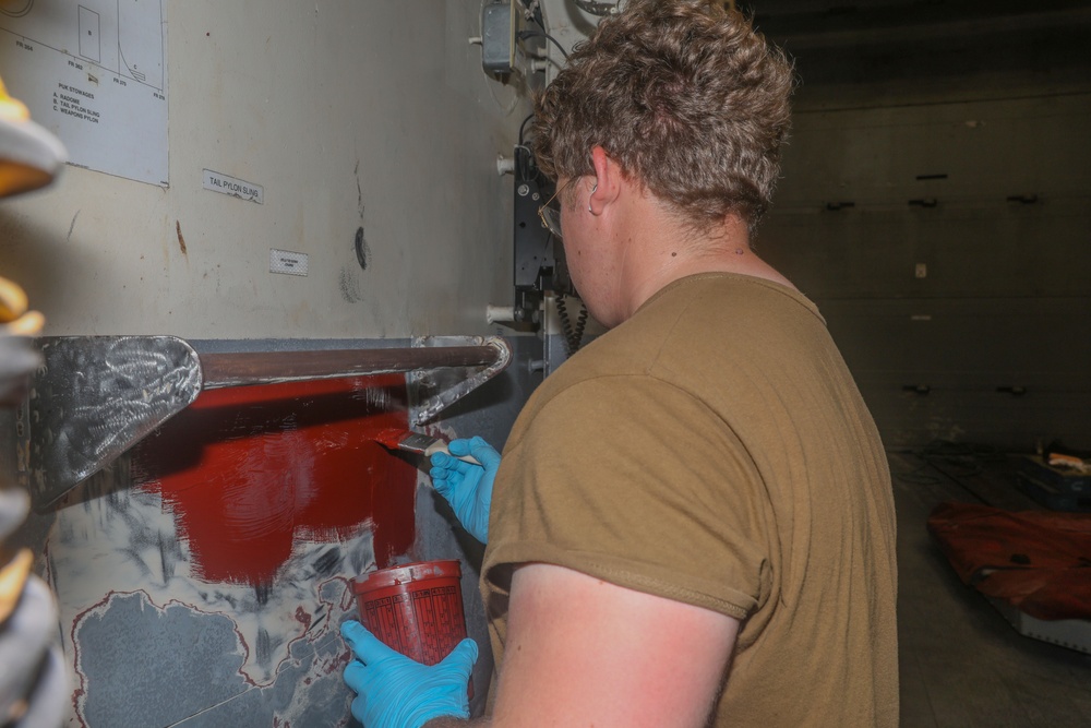 Sailors aboard the USS Howard apply primer to the ship's bulkhead in the South China Sea