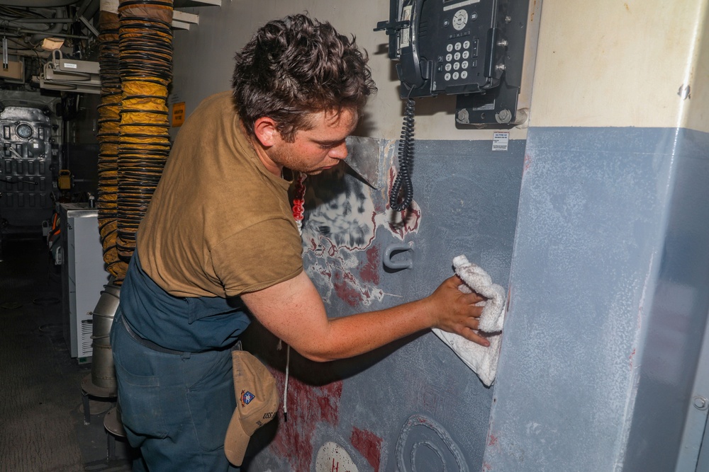 Sailors aboard the USS Howard apply primer to the ship's bulkhead in the South China Sea