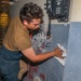 Sailors aboard the USS Howard apply primer to the ship's bulkhead in the South China Sea