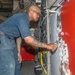 Sailors aboard the USS Howard apply primer to the ship's bulkhead in the South China Sea