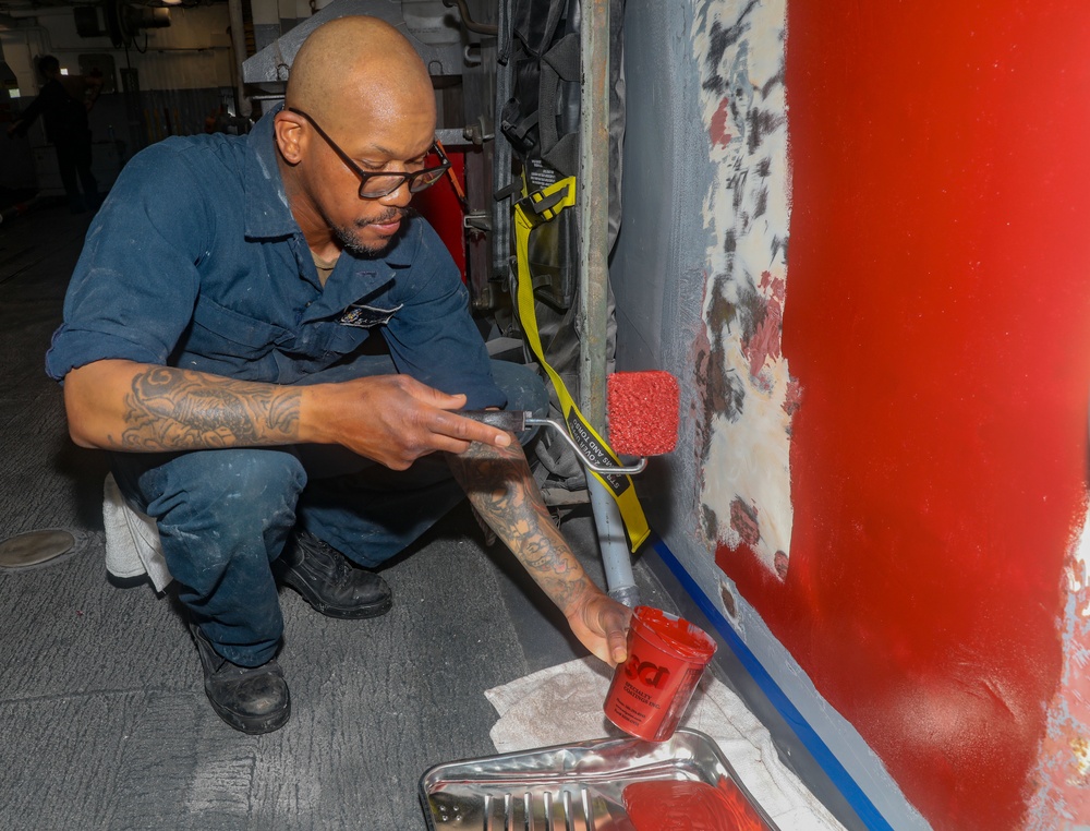 Sailors aboard the USS Howard apply primer to the ship's bulkhead in the South China Sea