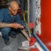 Sailors aboard the USS Howard apply primer to the ship's bulkhead in the South China Sea