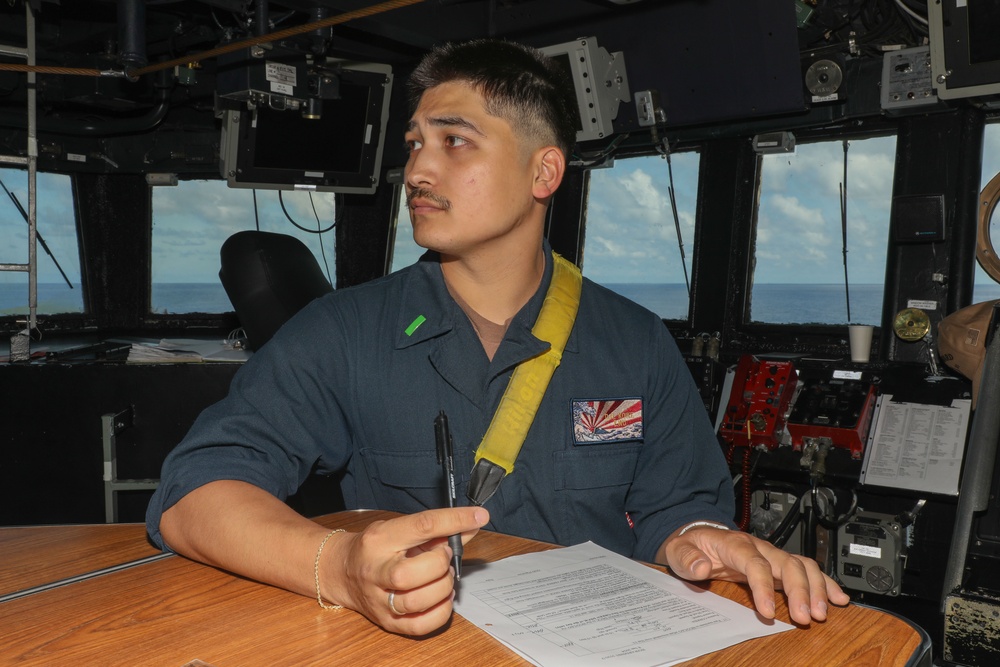 Sailors aboard the USS Howard stand watch in the pilothouse in the South China Sea