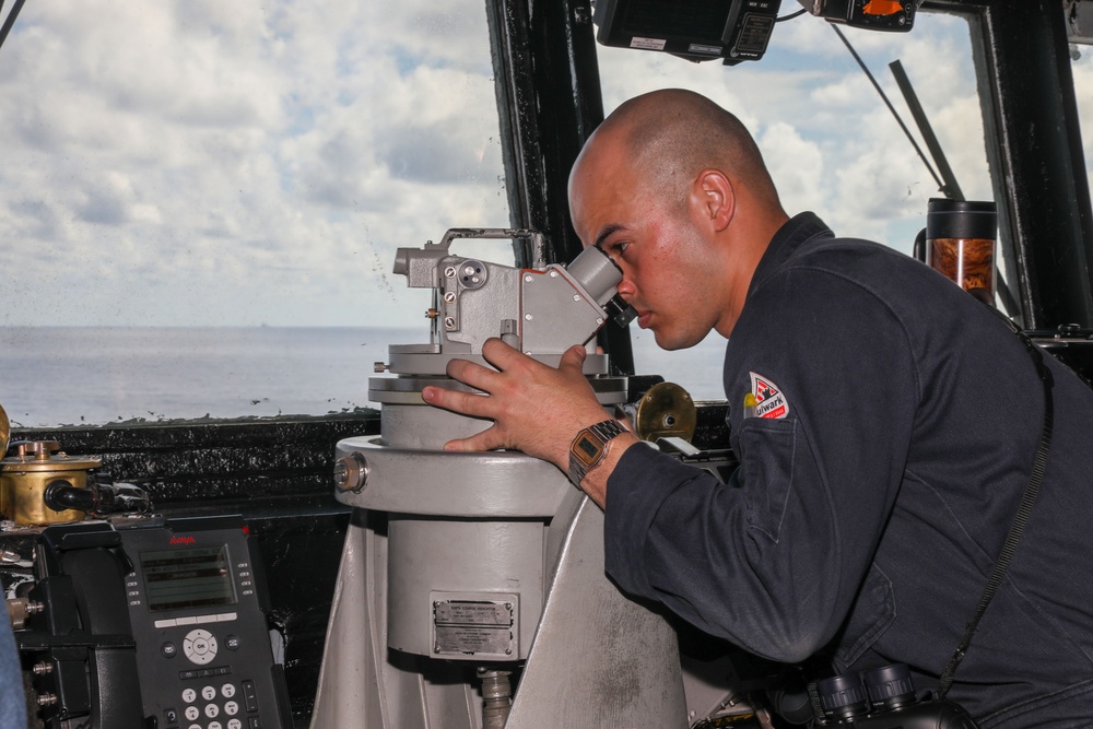 Sailors aboard the USS Howard stand watch in the pilothouse in the South China Sea