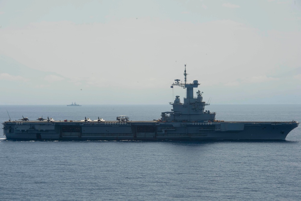 FS Charles De Gaulle (R91) passes alongside the Nimitz-class aircraft carrier USS Dwight D. Eisenhower (CVN 69) in the Mediterranean Sea