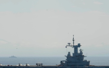 FS Charles De Gaulle (R91) passes alongside the Nimitz-class aircraft carrier USS Dwight D. Eisenhower (CVN 69) in the Mediterranean Sea