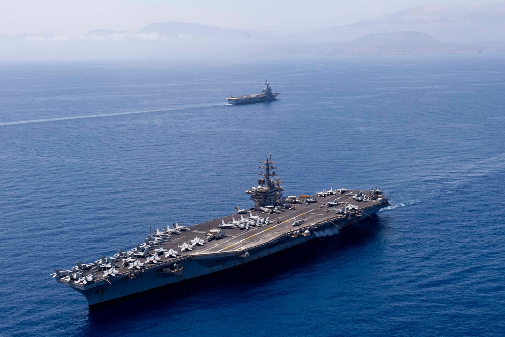 FS Charles De Gaulle (R91) passes alongside the Nimitz-class aircraft carrier USS Dwight D. Eisenhower (CVN 69) in the Mediterranean Sea