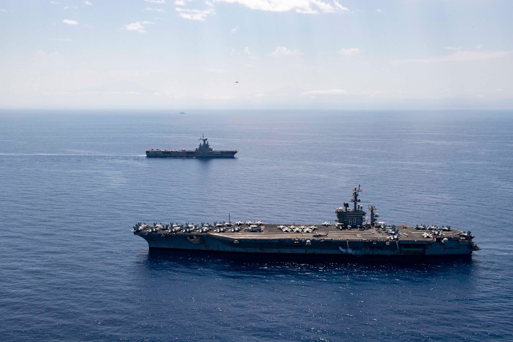 FS Charles De Gaulle (R91) passes alongside the Nimitz-class aircraft carrier USS Dwight D. Eisenhower (CVN 69) in the Mediterranean Sea