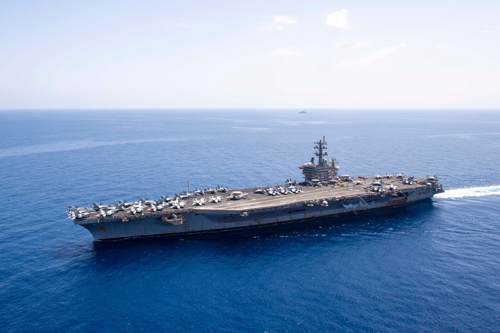 FS Charles De Gaulle (R91) passes alongside the Nimitz-class aircraft carrier USS Dwight D. Eisenhower (CVN 69) in the Mediterranean Sea