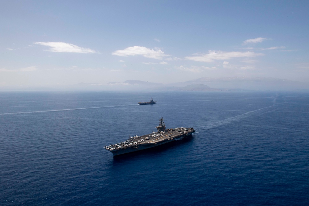 FS Charles De Gaulle (R91) passes alongside the Nimitz-class aircraft carrier USS Dwight D. Eisenhower (CVN 69) in the Mediterranean Sea