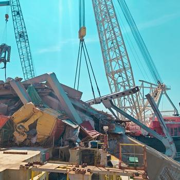 Salvors remove a piece of Key Bridge wreckage from M/V Dali