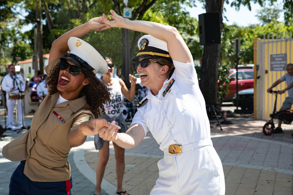 Cpl. Elizabeth Bido, from the Bronx, NY, assigned to the 2nd Combat Readiness Regiment and Lt Lillian Mcbee, from Miami, assigned to the Littoral Combat Ship Squadron (LCSRON) 2, dance in Domino Park in Miami during Miami Fleet Week, May 8, 2024.