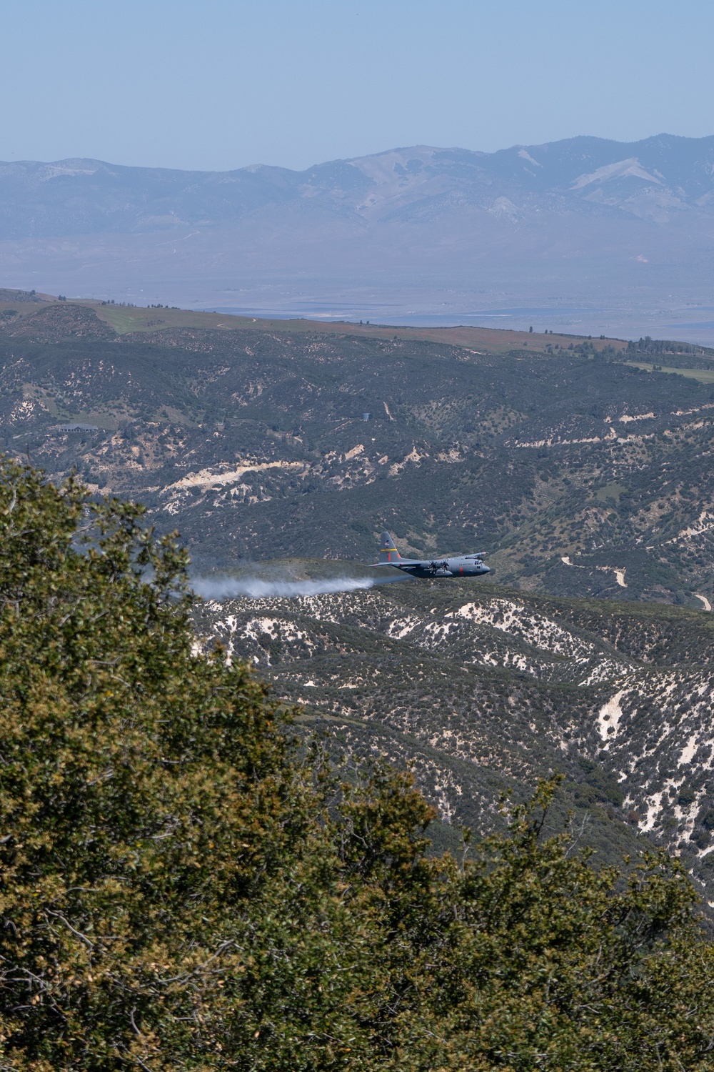 A C-130 (MAFFS 1) from Wyoming Air National Guard's 153rd Airlift Wing performs a water drop May 8, 2024, during Modular Airborne Fire Fighting System (MAFFS) Spring Training 2024