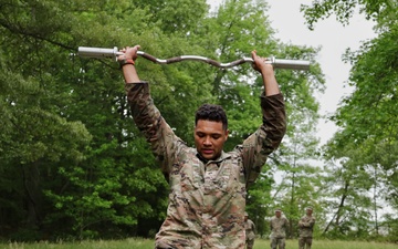 Maryland Army National Guard Soldier Steps Over Hurdles while Holding an EZ Bar During the Region II Best Warrior Competition