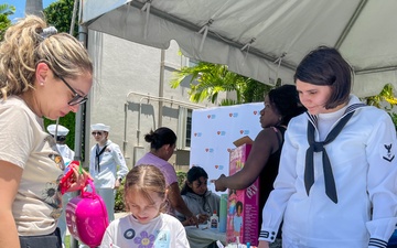 U.S. Navy Intelligence Specialist 3rd Class watches a Nicklaus Children’s Hospital patient color an art project at a community outreach event as part of Fleet Week Miami on May 9, 2024.