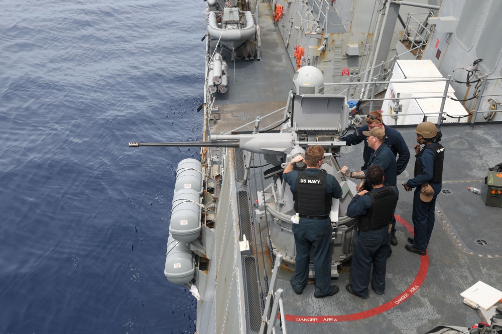 Sailors aboard the USS Howard perform maintenance on an MK 38 25mm chain gun in the South China Sea