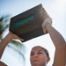 U.S. Navy Aviation Electronics Technician 2nd Class Rebecca Filgueiras, from Boca Raton, Fla., competes in an ammunition box pick-up contest during the “Top Gun” Beach Olympics event in Miami Beach, Fla., during Fleet Week Miami, May 11, 2024.