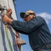 Sailors aboard the USS Howard conduct maintenance on the ship's exterior bulkhead in the South China Sea