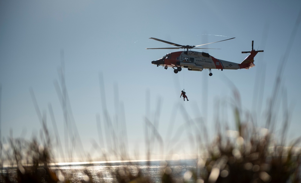 Coast Guard MH-60 Jayhawk and MH-65 Dolphin helicopter aircrews train near North Head Lighthouse in Cape Disappointment State Park, Washington