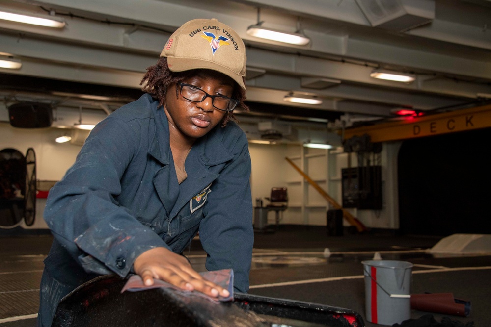 A Sailor conducts restoration efforts in the forecastle of USS Carl Vinson