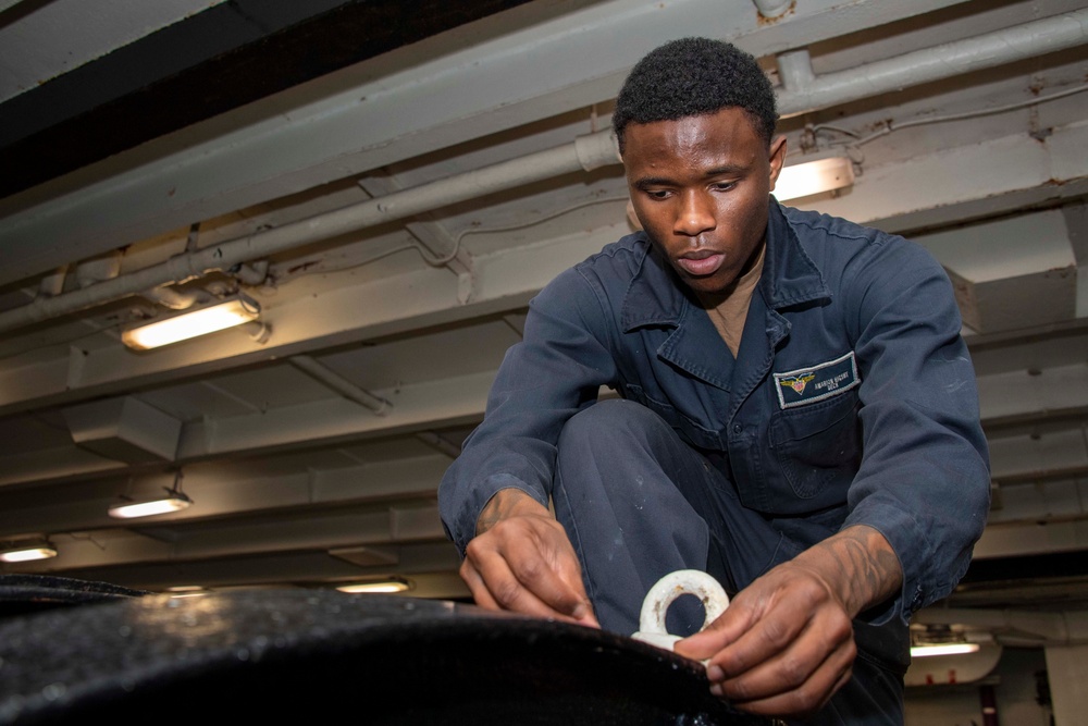 A Sailor conducts restoration efforts in the forecastle of USS Carl Vinson