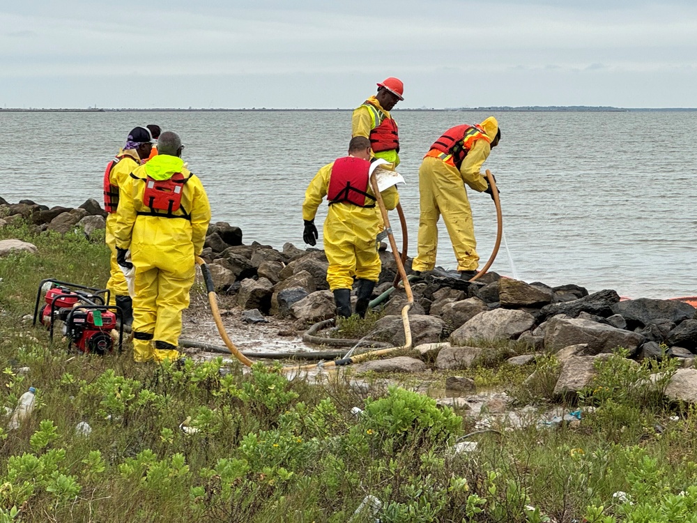 Pollution responders with E3 OMI clean oil off the rocks in the vicinity of Swan Lake near Galveston, Texas, May 17, 2024. After a barge allided with the Pelican Island Bridge on May 15, vacuum gas oil discharged into the Galveston Ship Channel. (U.S. Coast Guard photo, courtesy Texas General Land Office)