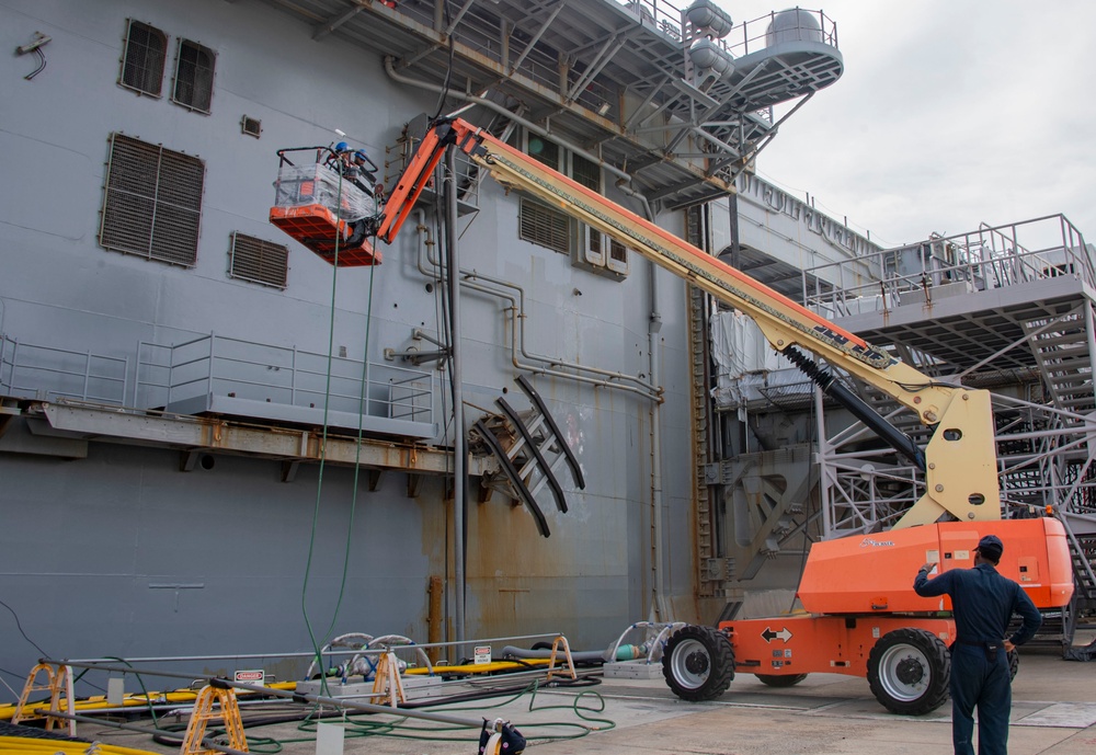 Sailors, assigned to the amphibious assault ship, USS America (LHA 6), conduct preservation work