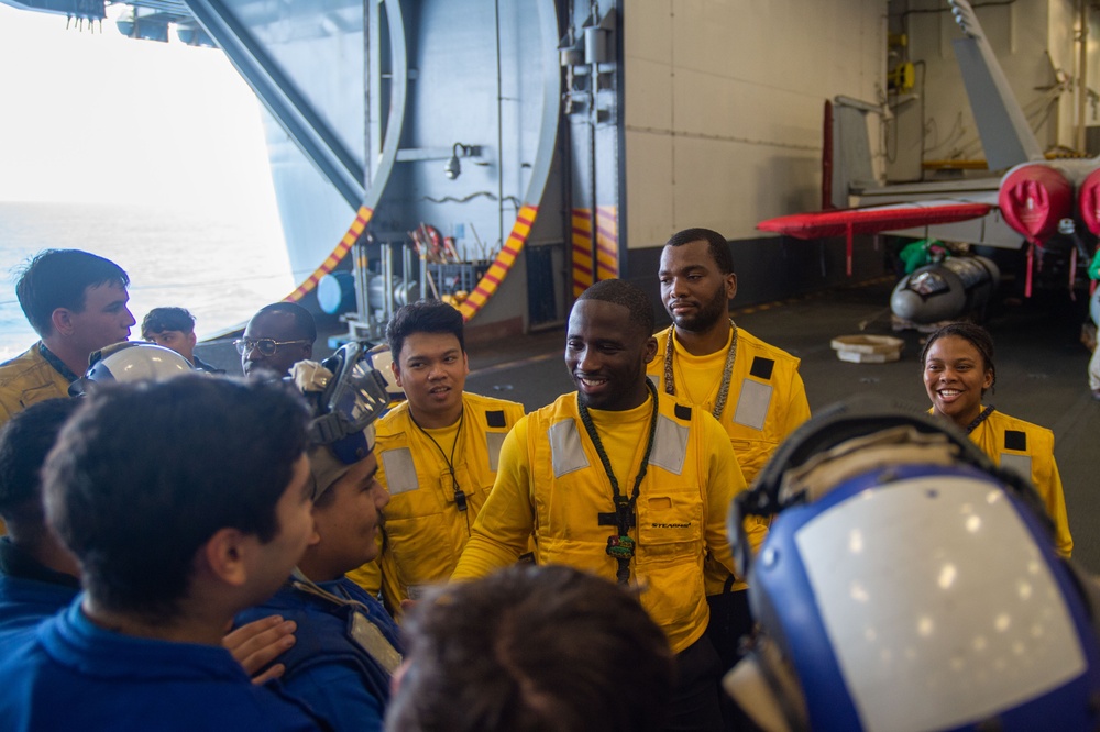 USS Ronald Reagan (CVN 76) Sailors move aircraft in hangar bay