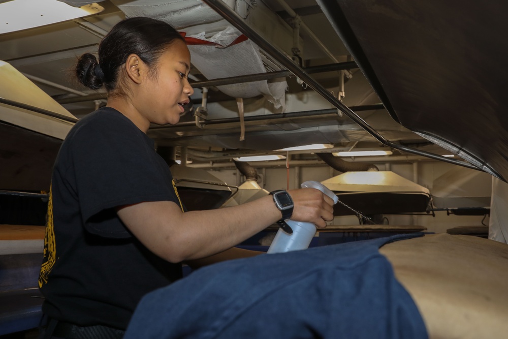 Sailor presses laundry aboard Abraham Lincoln