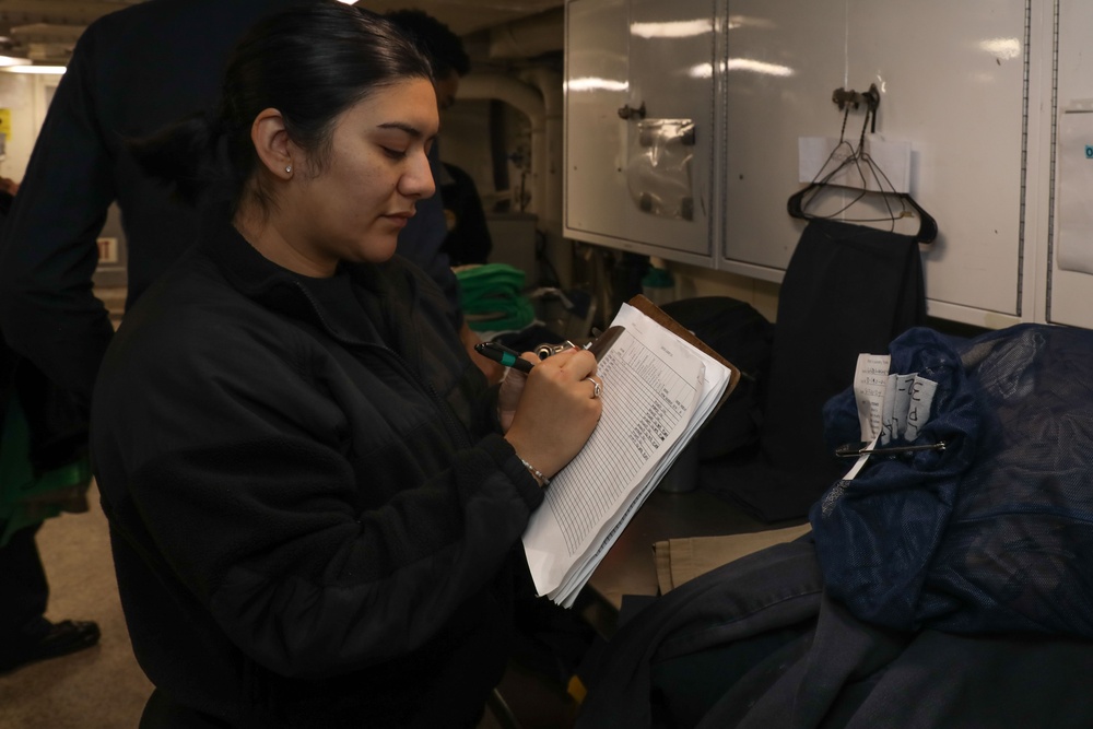 Sailor presses laundry aboard Abraham Lincoln
