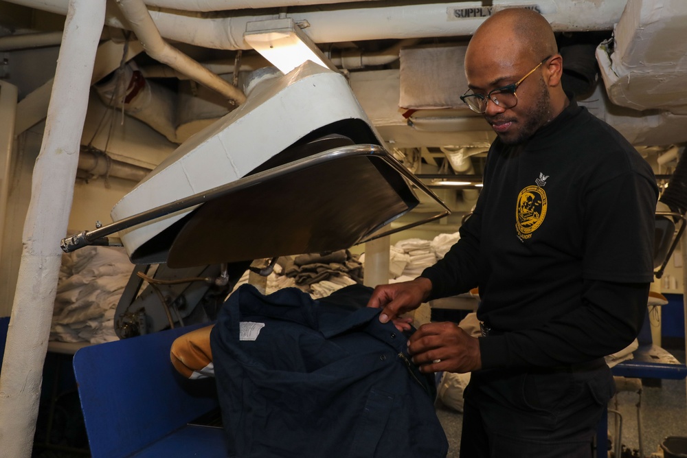 Sailor presses laundry aboard Abraham Lincoln