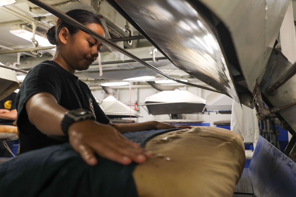 Sailor presses laundry aboard Abraham Lincoln