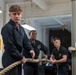 Sailors heave lines aboard USS Tripoli