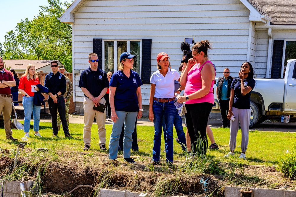 Federal and State Officials Walk around an Iowa Neighborhood Damaged by a Tornado
