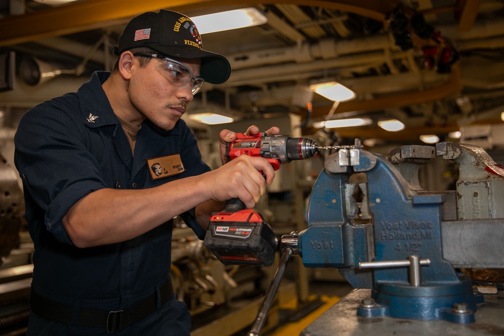 Sailor extracts bolts aboard Abraham Lincoln