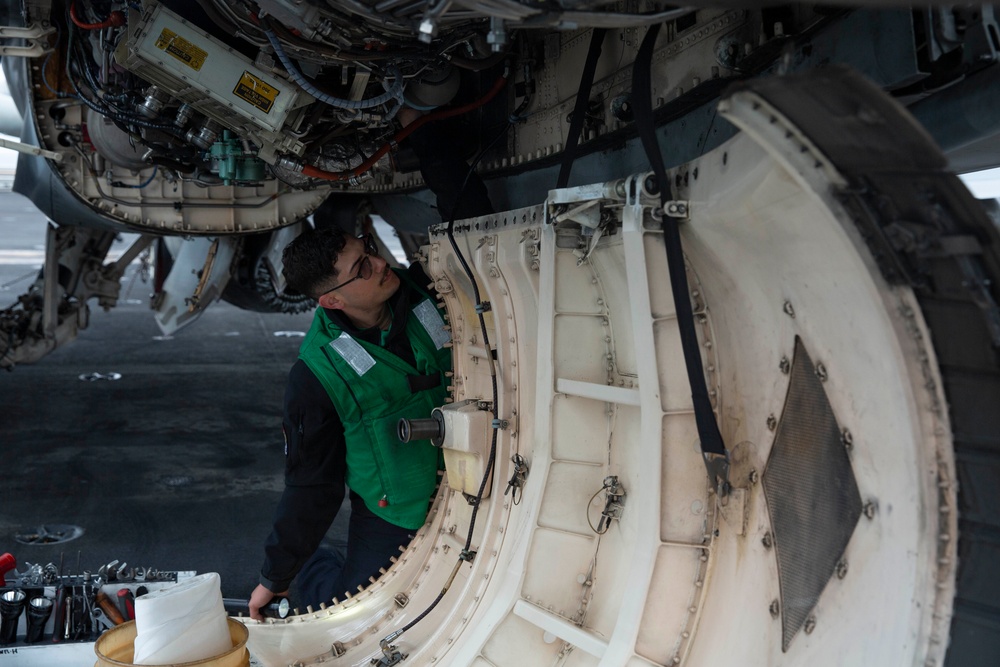 Sailor inspects an aircraft aboard Abraham Lincoln