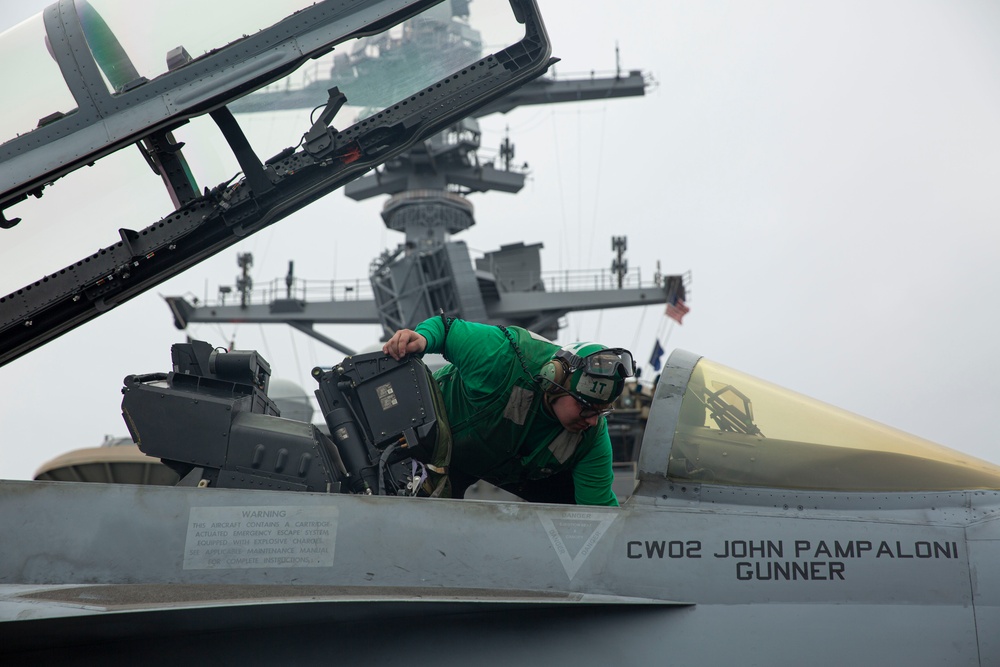 Sailor conducts a release and control check on an aircraft aboard Abraham Lincoln