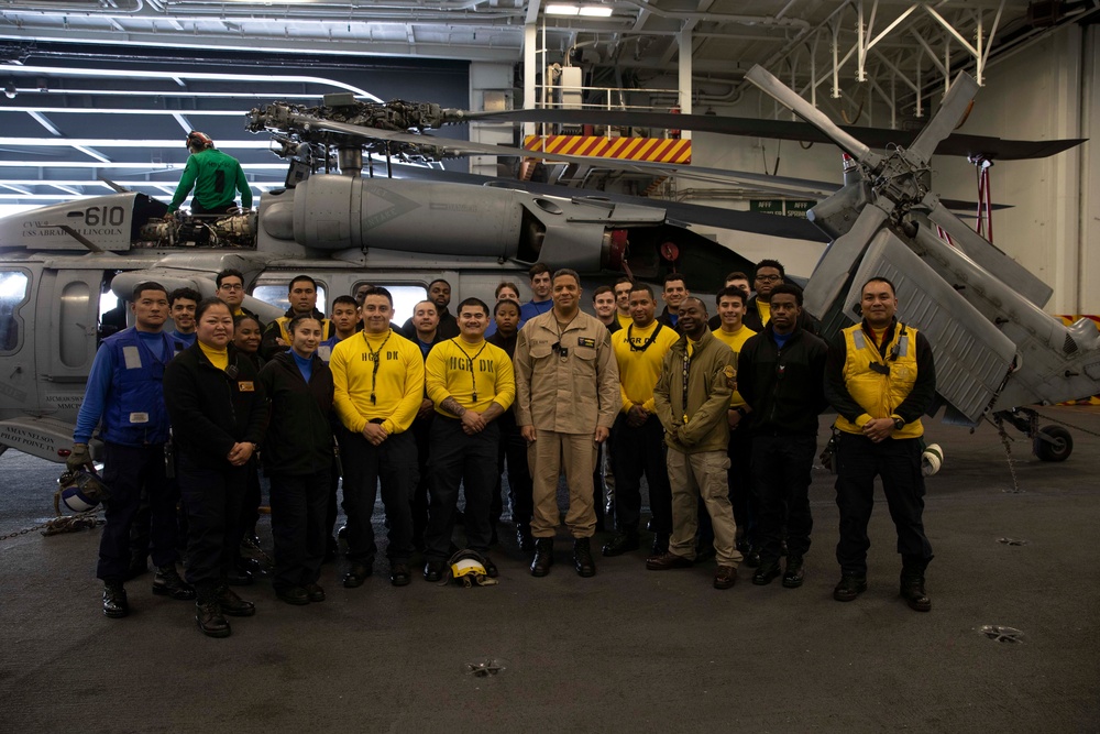 Rear Adm. Adan Cruz poses with Sailors aboard Abraham Lincoln