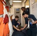 Sailors aboard the USS Howard conduct a medical emergency drill in front of the ship's store in the South China Sea