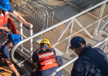 U.S. Coast Guardsmen attach brow to USCGC Calhoun