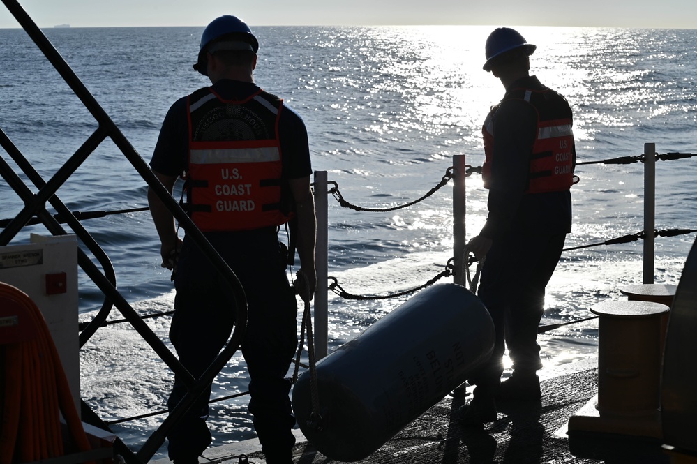 U.S. Coast Guardsmen transport fender aboard USCGC Calhoun